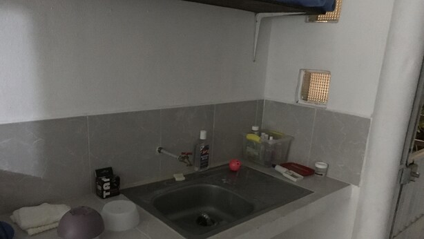 A small bathroom with a sink, a mirror, and a towel rack.