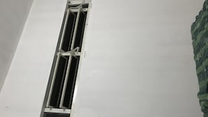 A window with a metal frame and a small opening at the bottom.