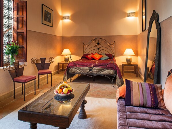 A cozy bedroom with a bed, two bedside tables, a sofa, a coffee table, and a mirror. - Riad darhani  Marrakech (Marrakech)