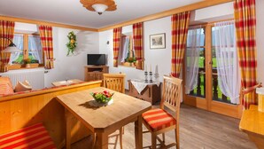 Una habitación acogedora con una mesa de comedor de madera, un banco y un televisor.