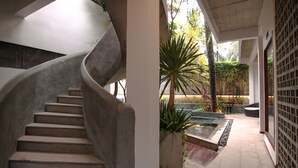Una escalera de caracol conduce a un espacio exterior cubierto con piscina y zona de estar.