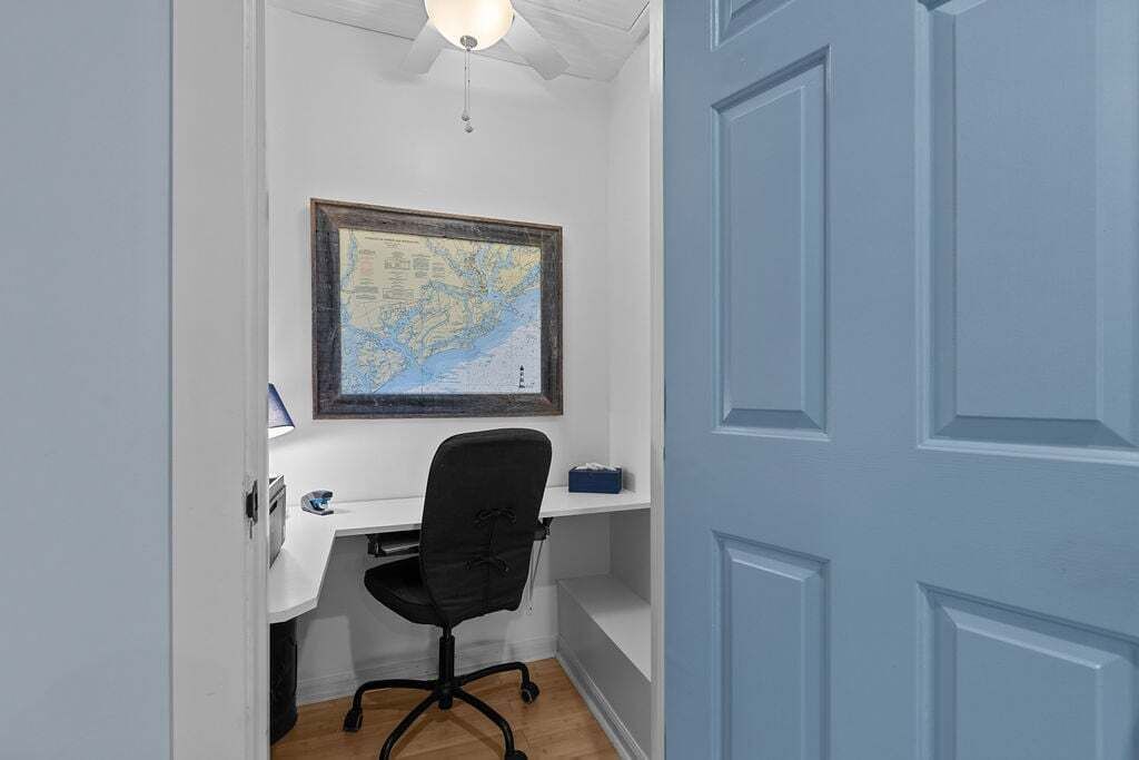 A room with a desk, chair, and a map on the wall.