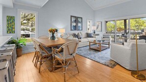 A spacious living room with a dining area, a sofa set, and a large window offering a view of the outdoors. - Cozy 3BR / 3.5 BA Retreat - Neighborhood Pool!  access included! (Johns Island)