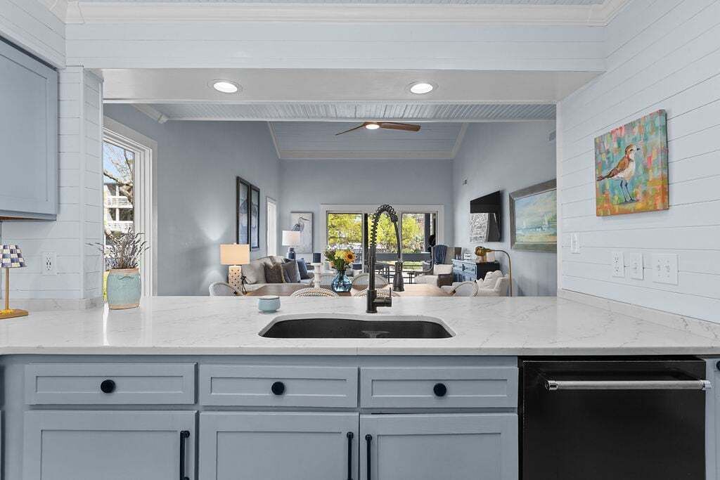 A kitchen with a sink, cabinets, and a dishwasher.