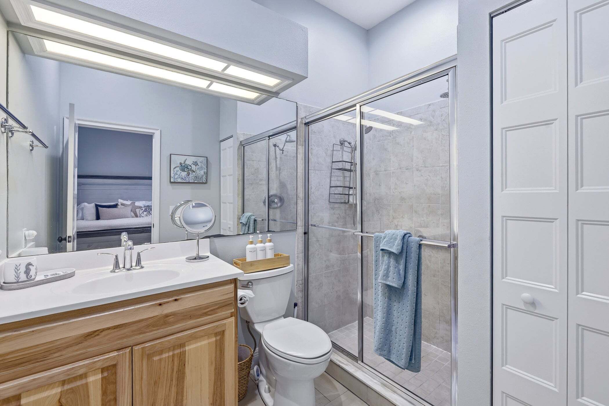 A bathroom with a shower, toilet, and vanity.