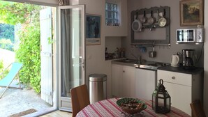 A kitchen with a dining area, a sliding glass door to the outside, and various kitchen appliances. - House open on the countryside  (Albas)