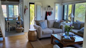 Ein geräumiges Wohnzimmer mit einer Couch, einem Couchtisch und einem Essbereich mit Tisch und Stühlen.