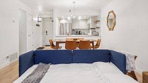 Een moderne hotelkamer met een groot bed, een eettafel en een kitchenette.
