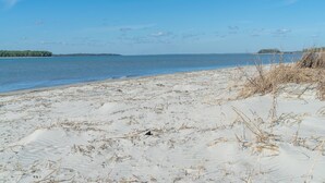 A sandy beach with a clear sky and calm water. - View of Edisto & Ocean! Walk to Pools, Golf! Amenity Access included! (Seabrook Island)