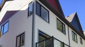 Une maison moderne à deux étages, dotée d’un balcon, de fondations en briques et d’un appareil de climatisation.