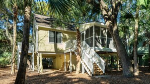 A two-story house with a covered porch and a staircase leading to the upper level. - Beachy Cottage! Short Ride to Beaches, Pools, Dining, Golf! Pet Friendly! Amenity access included (Seabrook Island)
