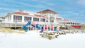 A beach house with a large deck, a gazebo, and multiple slides. - Beach Service Included, Private Beach, Chateau La Mer 10E! (Destin)