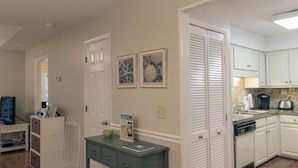 A modern kitchen with white cabinets, a built-in dishwasher, and a countertop with a coffee maker. - Adorable Cottage! Pet Friendly! 3 BR/2 BA w/ Golf Views! Amenity access! (Seabrook Island)