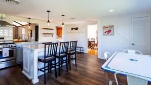 A modern kitchen with a central island, wooden flooring, and pendant lighting. - "Sea Gypsy"  Waterfront newly renovated, beautiful views, dock, beach! (Dennis)