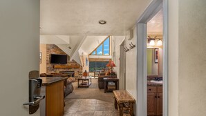 Un'ampia cucina con zoccolo in pietra, TV integrata e una grande finestra con vista panoramica.