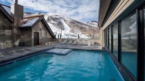 Piscina con vista su una montagna innevata.