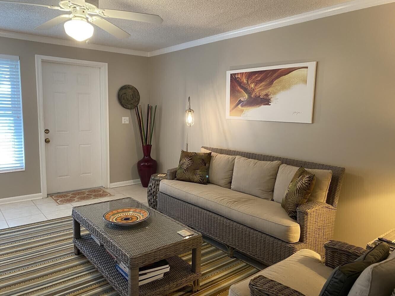 A living room with a sofa, coffee table, and a decorative vase.