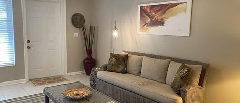 A living room with a sofa, coffee table, and a decorative vase.