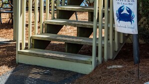 Una escalera de madera con un cartel que dice "The Water is Calling" en Seabrook Island.