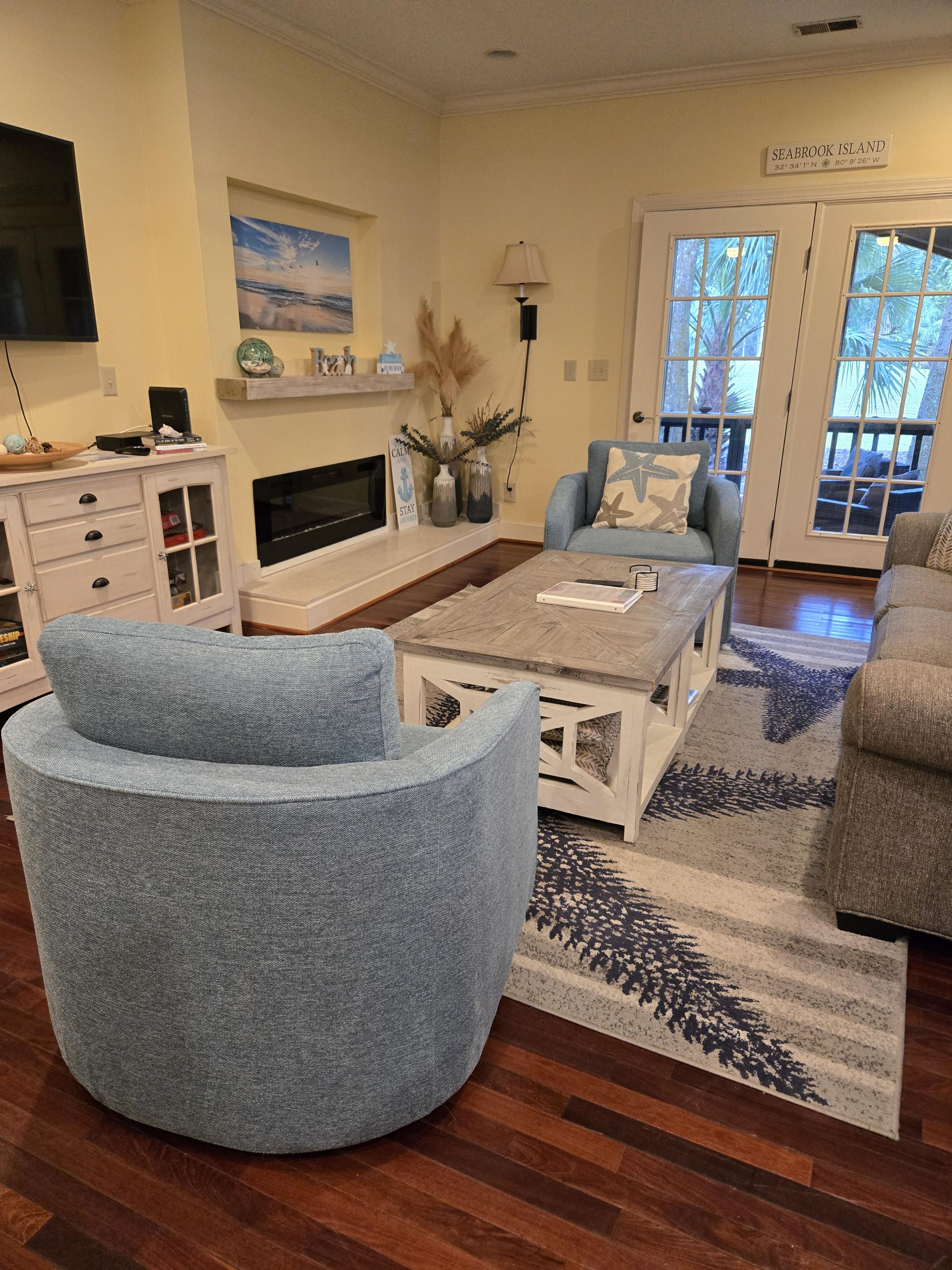 Een woonkamer met een open haard, een televisie en een bordje met de aanduiding Seabrook Island.