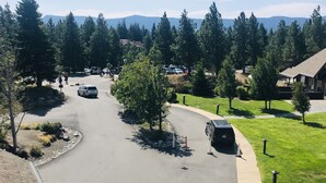 A residential driveway with parked cars, a curved road, and a grassy area with trees. - 3056 🏔Studio @ Suncadia-Hike, Bike, Golf, etc. (Cle Elum)