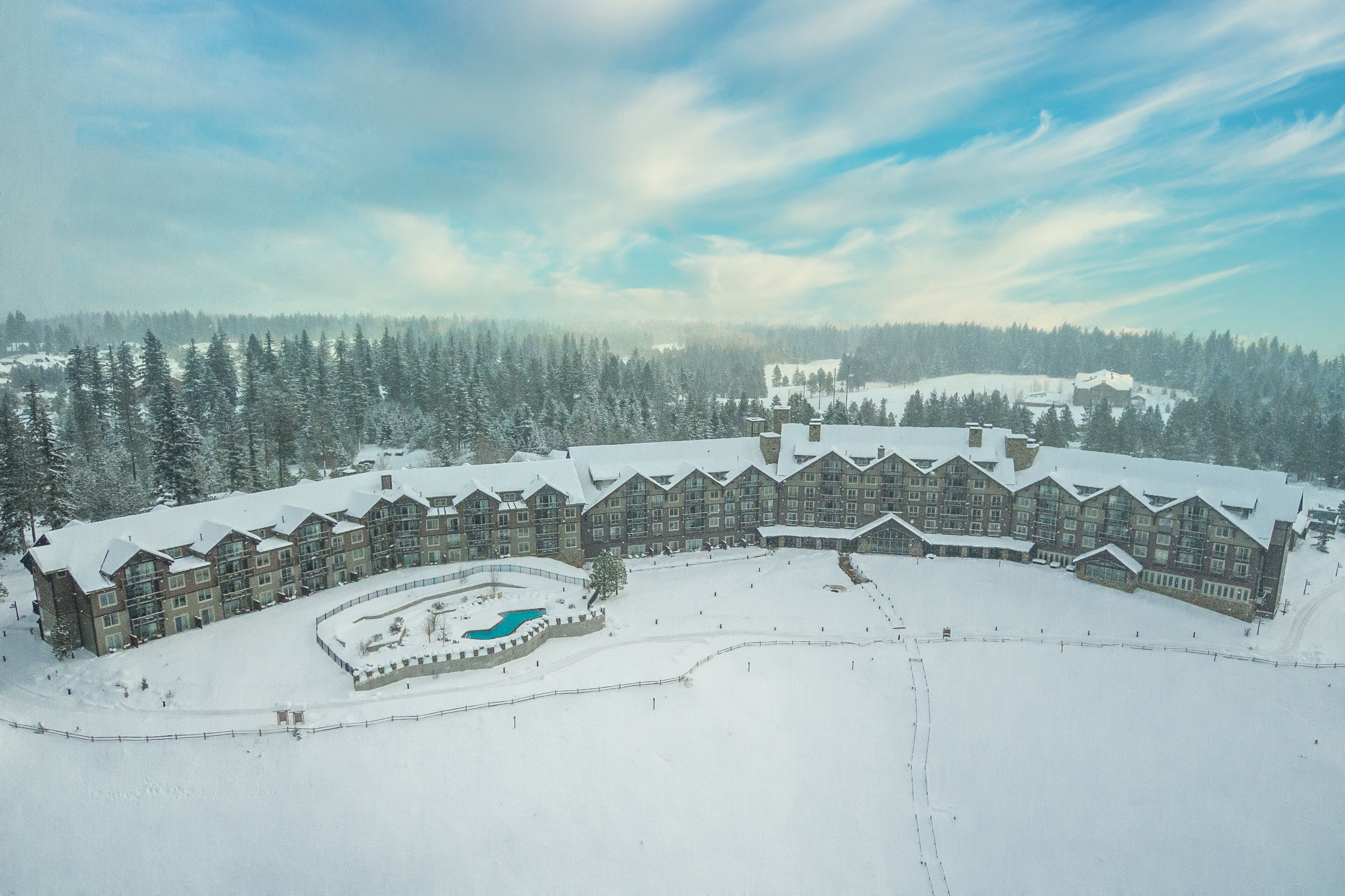 A large lodge with multiple buildings, a central courtyard, and a swimming pool.