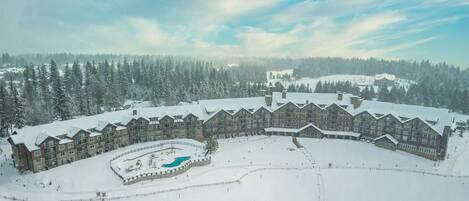 A large lodge with multiple buildings, a central courtyard, and a swimming pool.