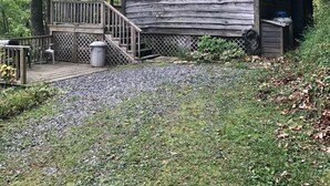 A rustic cabin with a wooden deck, a chimney, and a small porch. - Quiet Rustic Getaway (Whittier)
