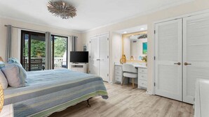 Ein Schlafzimmer mit Bett, Schreibtisch, Fernseher und Kleiderschrank.