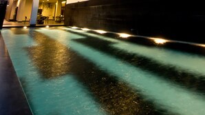 Un hotel modern amb diverses plantes i una zona de piscina.