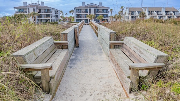 A wooden boardwalk leading to a beachfront property with multiple-story buildings. - Bright and Spacious 3 bedroom ocean front, ground floor condo (St. Augustine Beach)