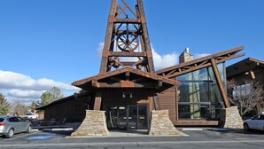 A building with a large wooden tower structure, a glass entrance, and stone pillars. - Prospector Top Floor - Slps up to 10 - Pool/Hot Tub On Site (Park City)