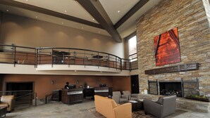 A spacious lobby with a stone fireplace, a reception desk, and a seating area with sofas and a coffee table. - Prospector Top Floor - Slps up to 10 - Pool/Hot Tub On Site (Park City)