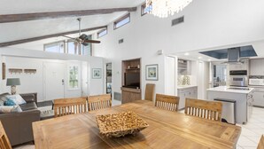 Una cocina amplia con electrodomésticos modernos, un comedor con mesa de madera y una zona de estar acogedora con sofá.