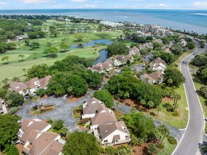 Ilmakuva asuinalueesta, jossa on taloja, golfkenttä ja vesialue.