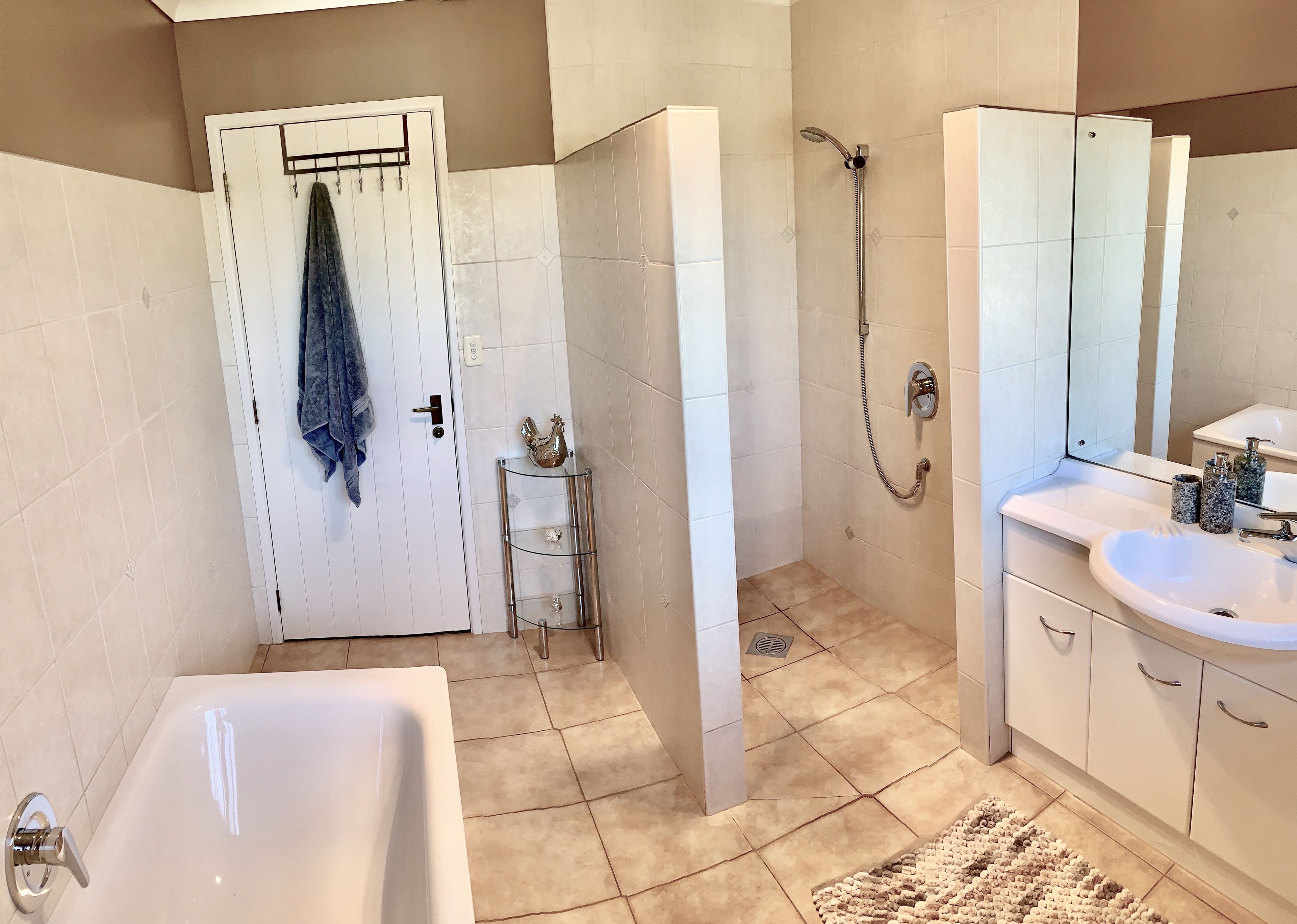 Une salle de bain avec une baignoire, une douche, un lavabo et un miroir.