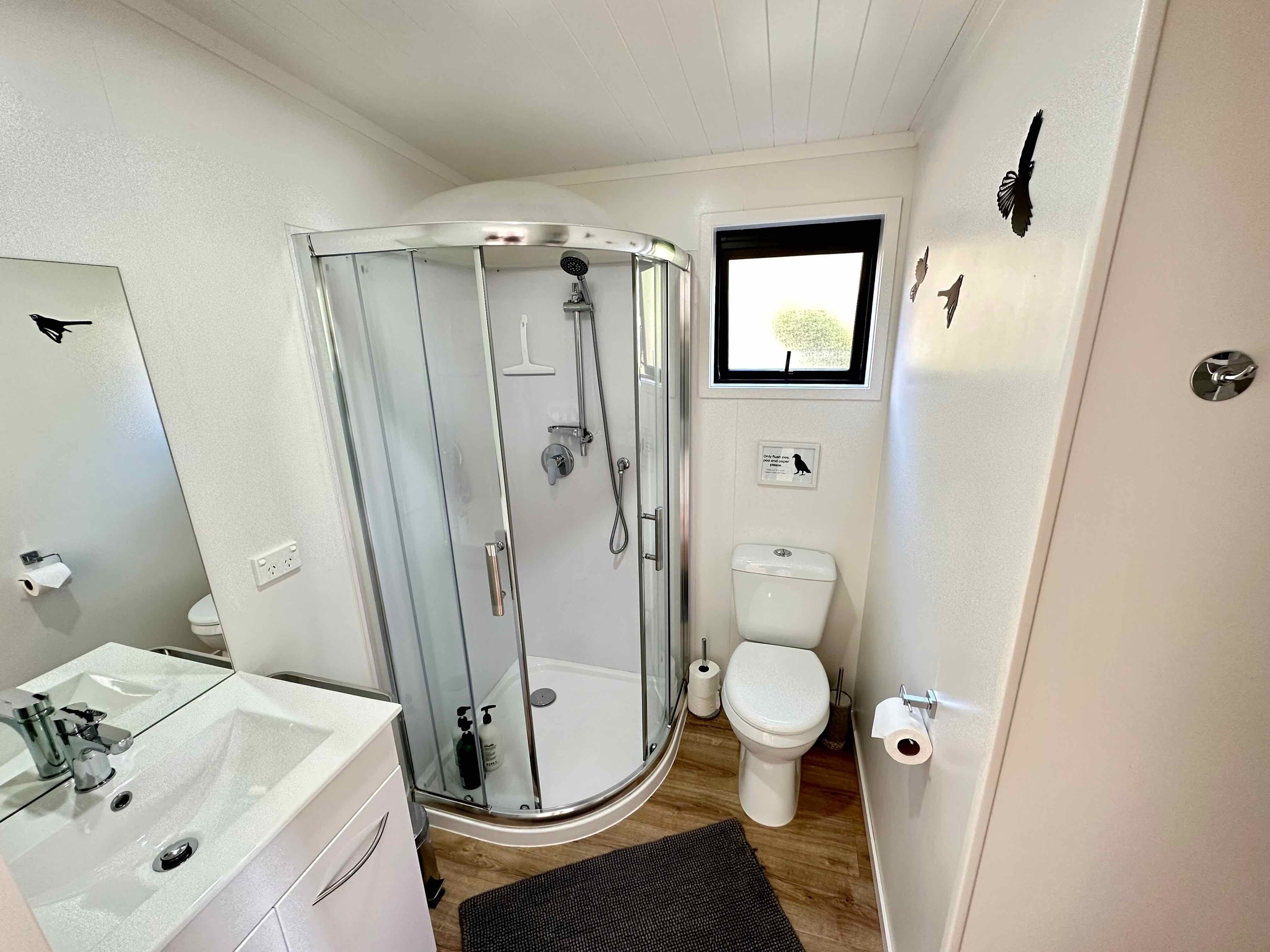Une salle de bain compacte avec une douche à parois de verre, des toilettes et un lavabo avec un miroir.