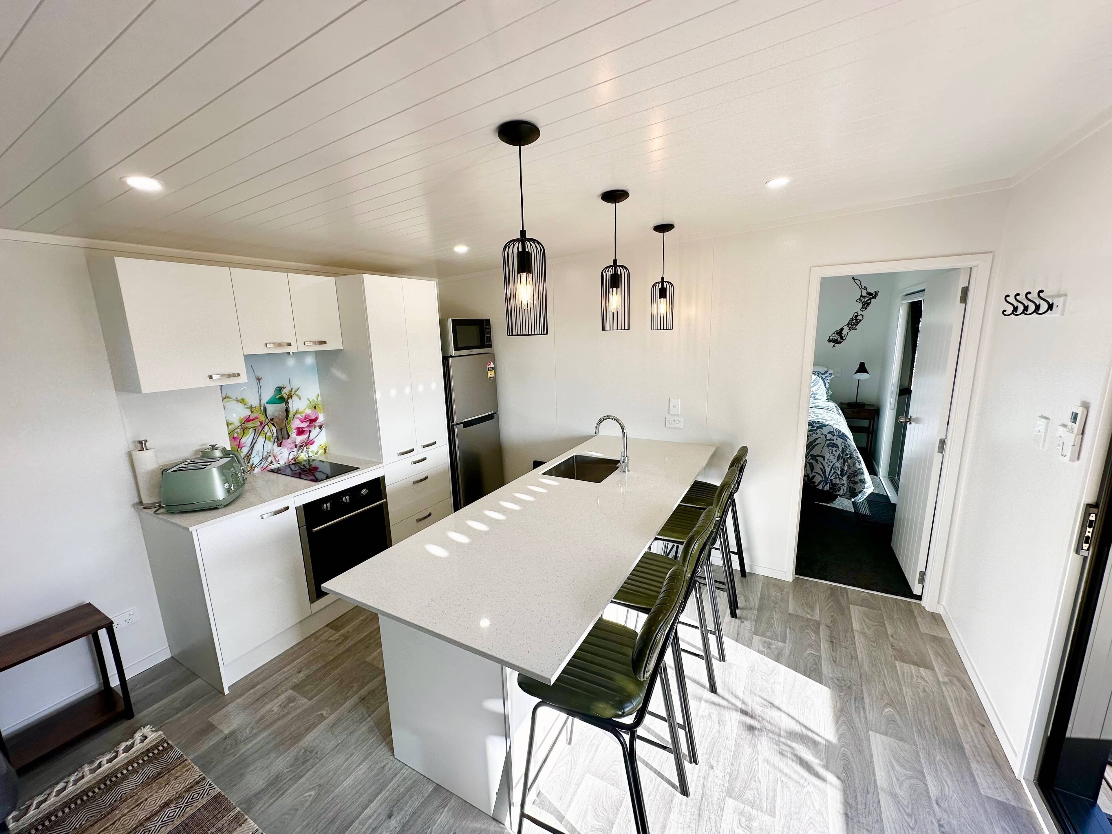 A modern kitchen with a central island, stainless steel appliances, and pendant lighting.