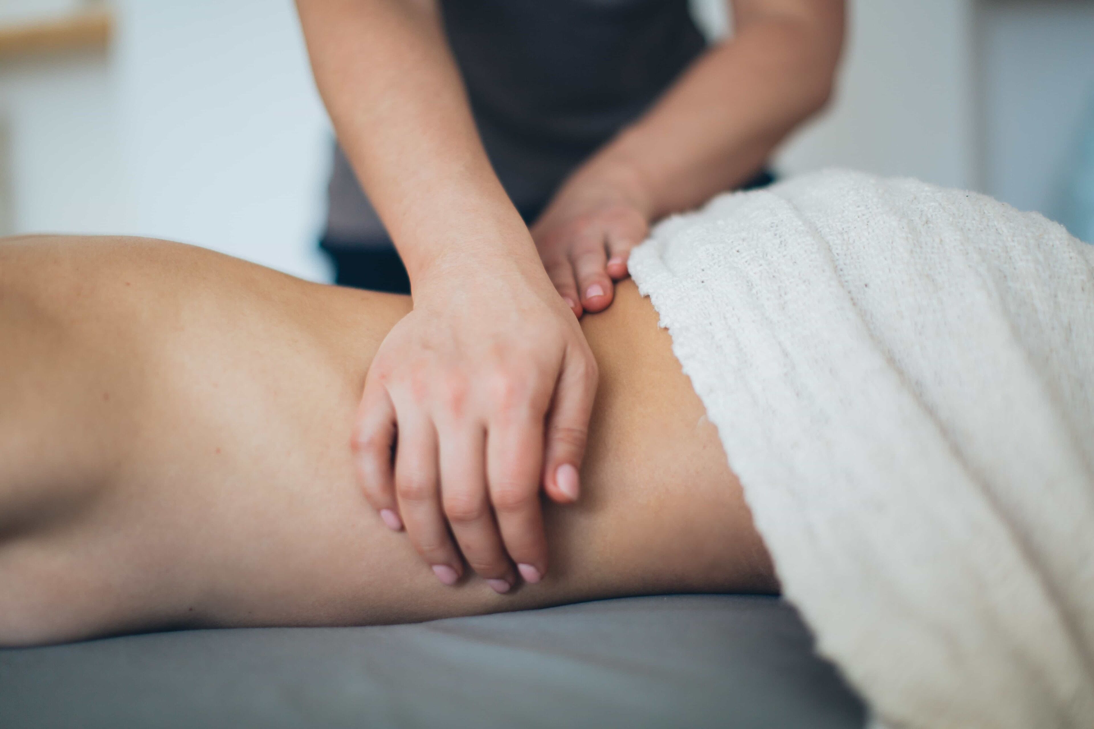 A person receiving a massage on a massage table.