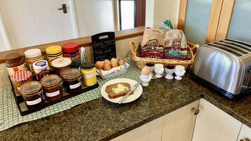 Una encimera de cocina con diferentes alimentos, un tostador y una cesta de pan.