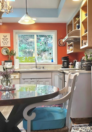 A kitchen with a window, a dining table, chairs, a chandelier, and a coffee maker. - 2 BEDROOM HIDEAWAY BY DISCOVERY PARK, FAMILIES, COUPLES, SOLO STAYS (Seattle)
