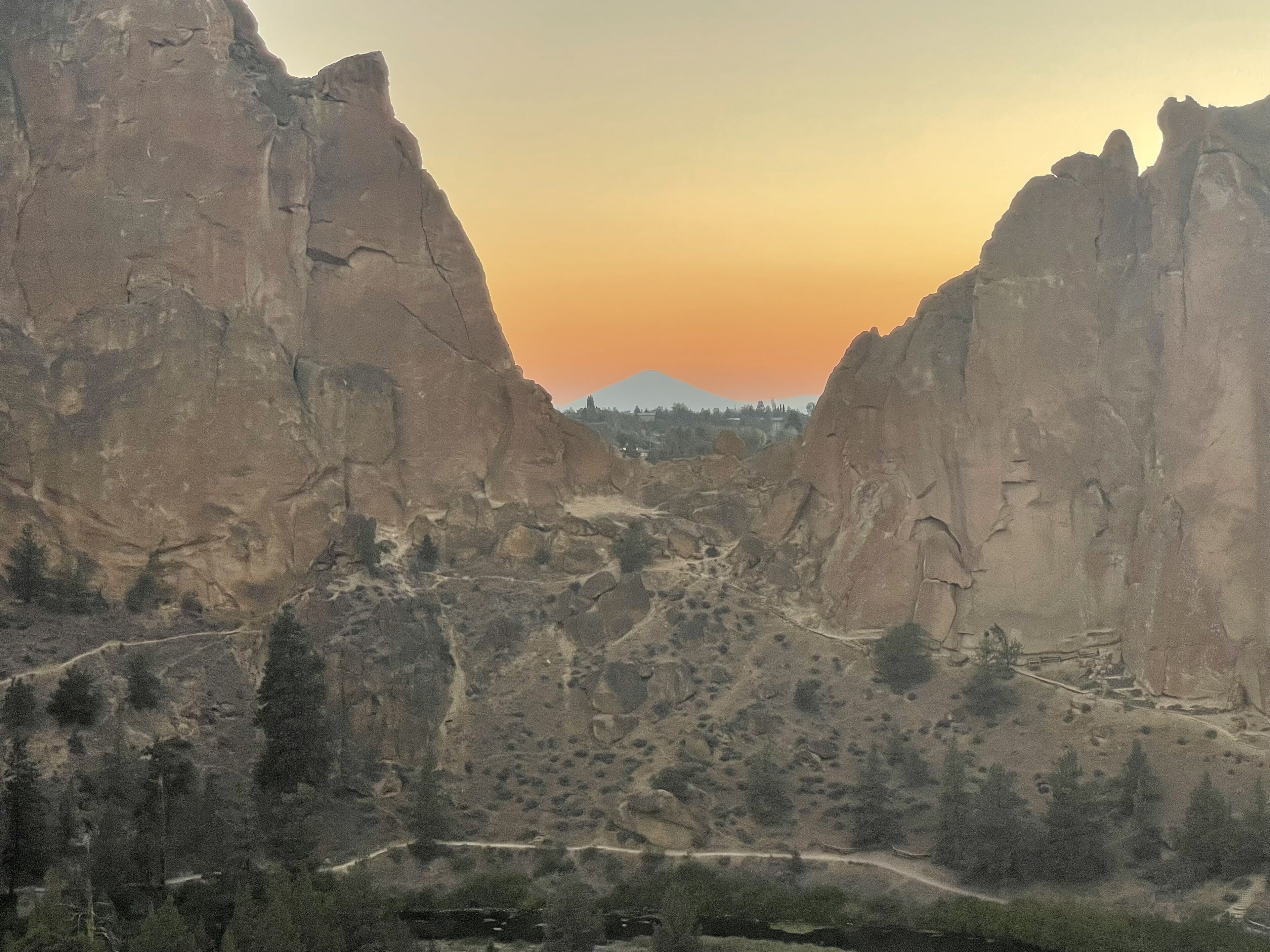 Un canyon con scogliere rocciose e una strada tortuosa.