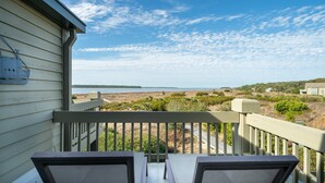 A balcony with a view of a beach and ocean.