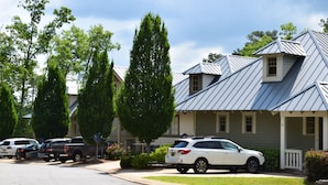 Una calle residencial con casas, coches aparcados y árboles.