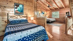 A cozy cabin-style room with a bed, a desk, and a window. - Best Panoramic Views! Hot Tub | Fire Pit | Top 10% (Sevierville)