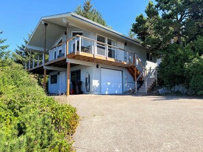 Une maison à deux étages avec un garage, un balcon et un escalier menant à l’étage supérieur.