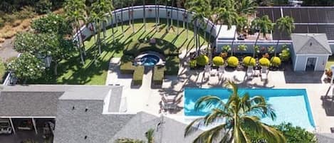 Ett semesterhotell med en swimmingpool, solstolar och palmer.