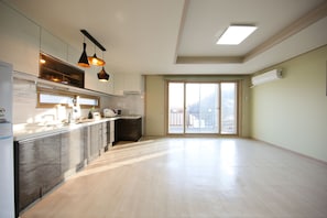 A spacious kitchen with modern appliances, a large island, and pendant lighting.