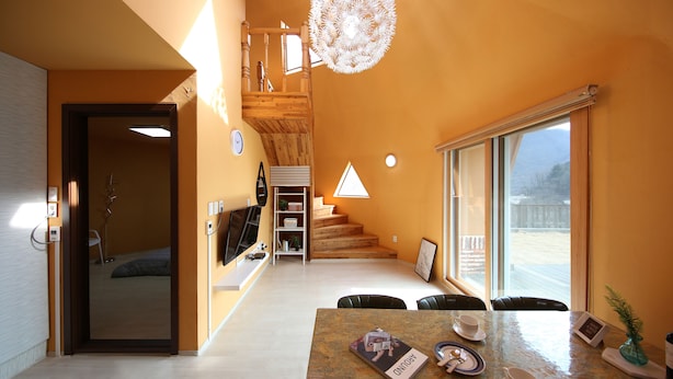 Un interior moderno con comedor, escalera y un amplio ventanal.