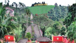 A paved road leading to a small red building surrounded by greenery, with a hill in the background. - Villa Sasky Ciater Highland (Ciater)